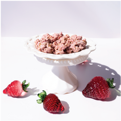 Happy Munch Yogurt Clusters Strawberry Splash in a white bowl with three strawberries on a white background