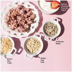 Happy Munch Yogurt Cluster Ingredients strawberries, yogurt, sunflower seeds, brown rice crisps, and gluten-free oats on a pink background.