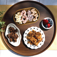 Happy Munch Factory yogurt clusters, Dark Choco Nuggets, and Naked Nuggets on a wooden serving tray.