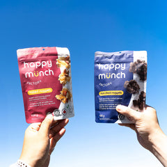Happy Munch Naked Nuggets and Happy Munch Dark Choco Nuggets held up to the sky