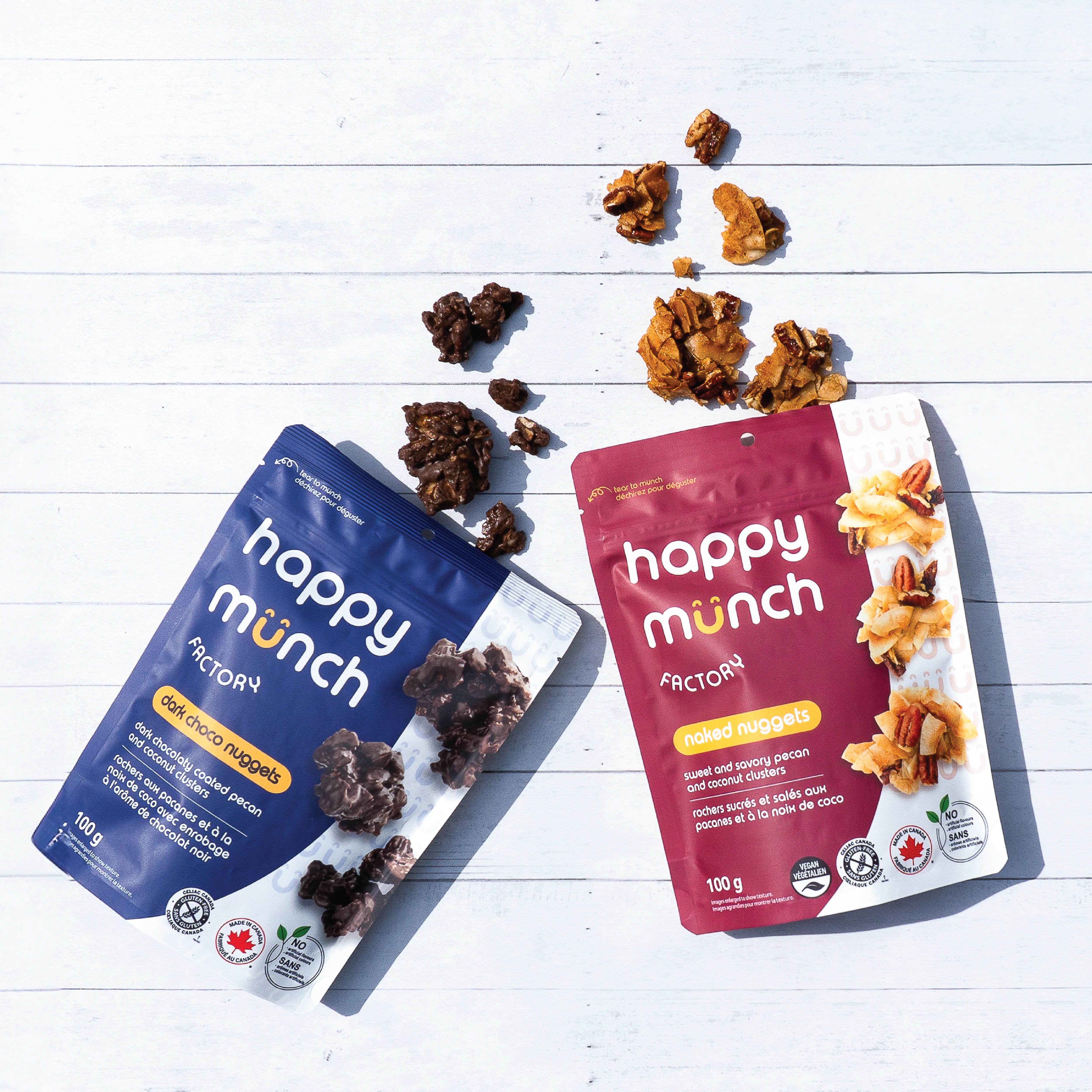 Happy munch naked nuggets and Happy Munch Dark Choco nuggets snacks on a white wooden surface with snacks spilling out.