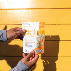 Happy Munch Mango Mania Yogurt clusters pouch held over yellow background.