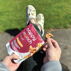 Person holding a 'happy munch naked nuggets' snack packet outdoors