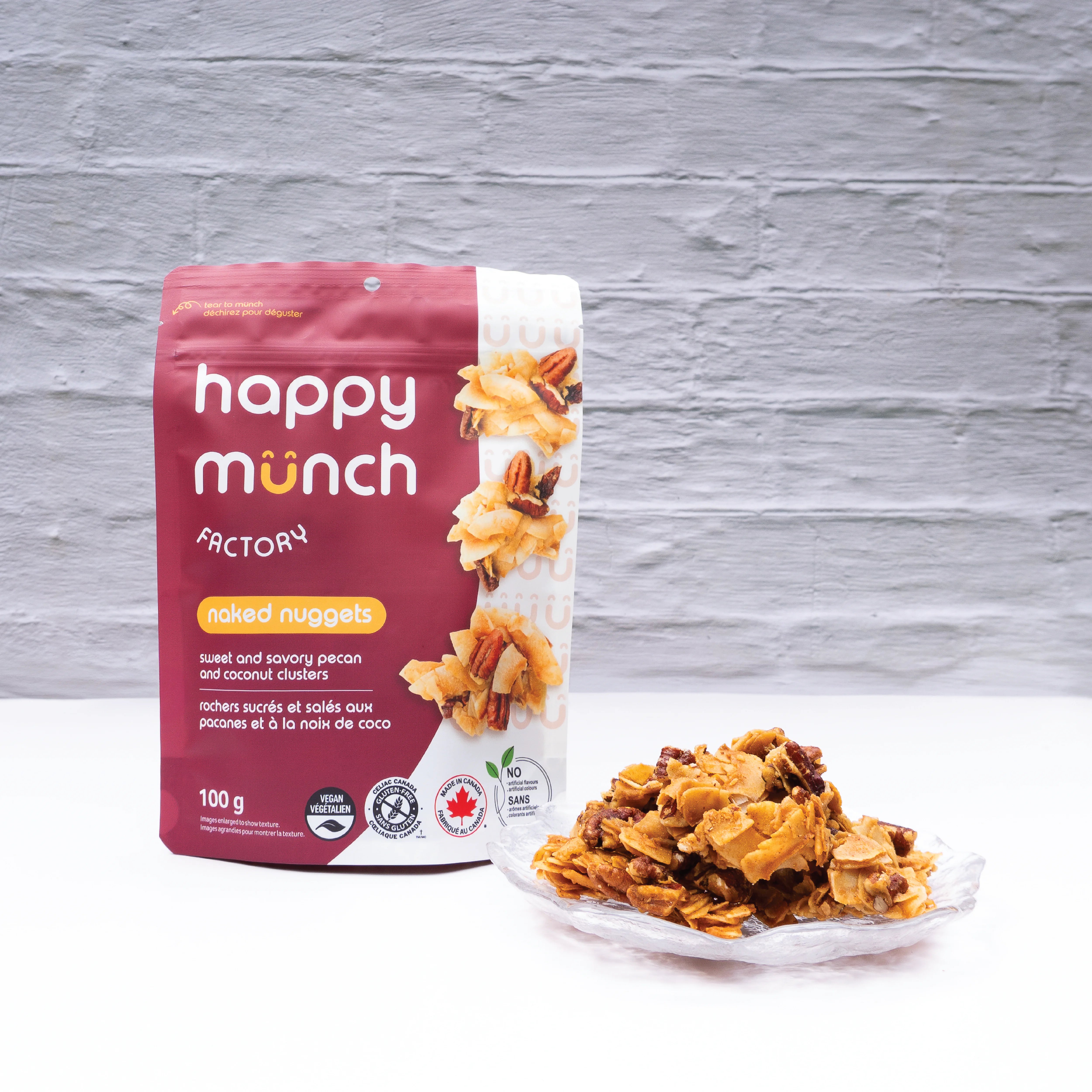 Happy Munch Naked Nuggets pouch with a plate of Naked Nuggets on a gray background