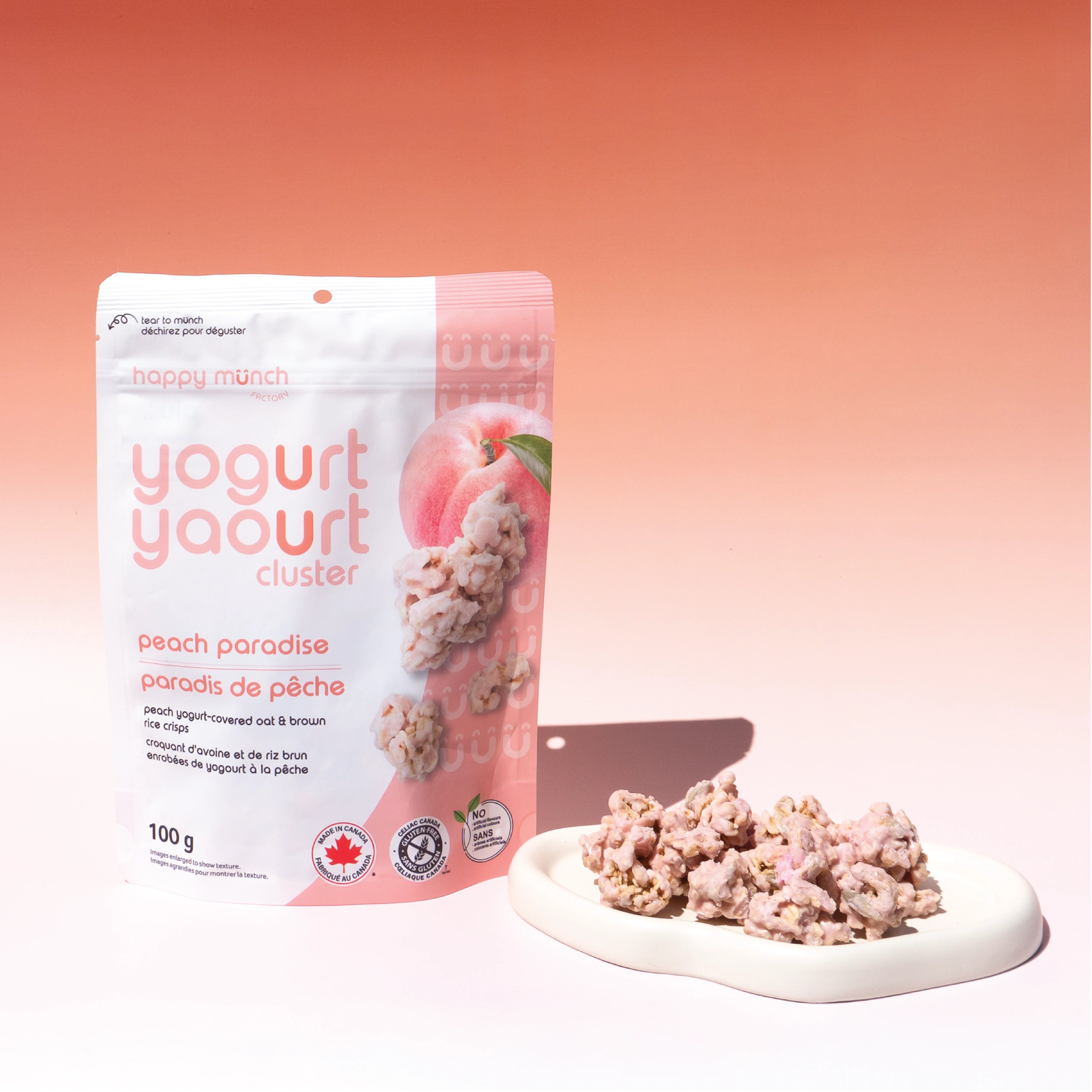 Happy Munch Peach Paradise yogurt cluster packaging with peach yogurt clusters on a plate with a peach pink background